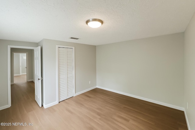 1109 Lake Shore Blvd, Jacksonville, FL 32205 - unfurnished bedroom with wood finished floors, baseboards, a closet, and a textured ceiling
