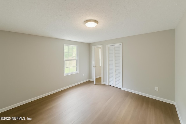 1109 Lake Shore Blvd, Jacksonville, FL 32205 - unfurnished bedroom with wood finished floors, baseboards, a closet, and a textured ceiling