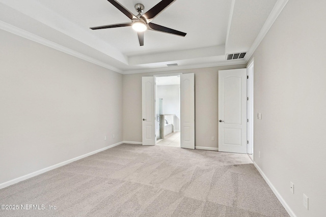 124 Medio Dr, Saint Augustine, FL 32095 - unfurnished bedroom featuring a tray ceiling, light carpet, ensuite bath, baseboards, and ceiling fan