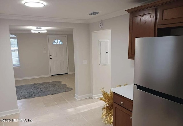 foyer featuring plenty of natural light, crown molding, baseboards, electric panel, and light tile patterned flooring