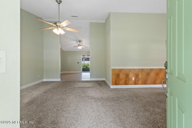 unfurnished room featuring ceiling fan, carpet floors, vaulted ceiling, and baseboards