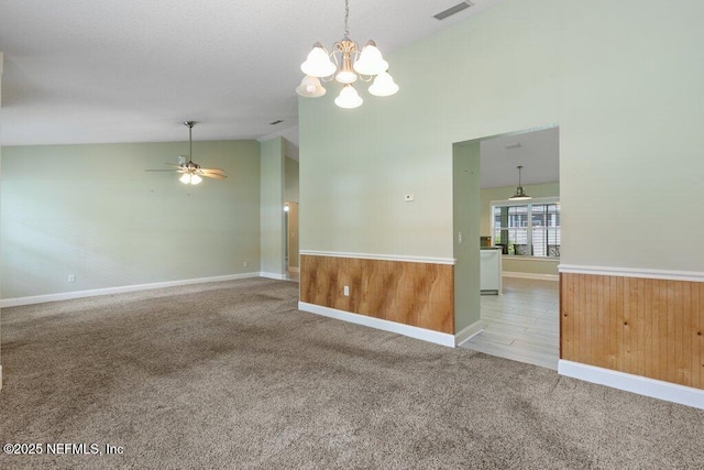 carpeted spare room with lofted ceiling, a chandelier, a ceiling fan, and baseboards