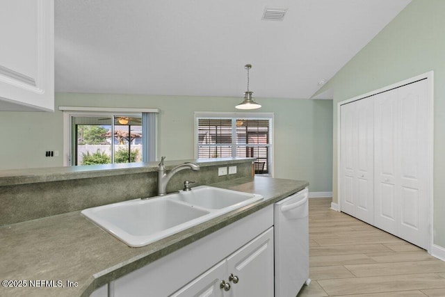 kitchen with dishwasher, a sink, white cabinets, decorative light fixtures, and lofted ceiling
