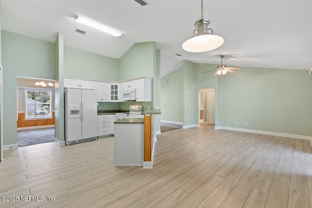 kitchen with white appliances, dark countertops, white cabinets, ceiling fan, and light wood-type flooring