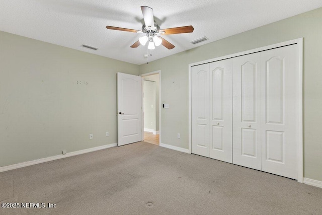 unfurnished bedroom featuring carpet, baseboards, a closet, a ceiling fan, and a textured ceiling