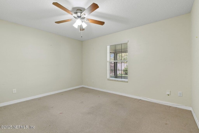 carpeted spare room featuring a ceiling fan, baseboards, and a textured ceiling