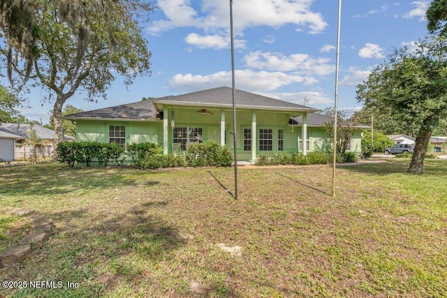 rear view of property with a yard, ceiling fan, and stucco siding