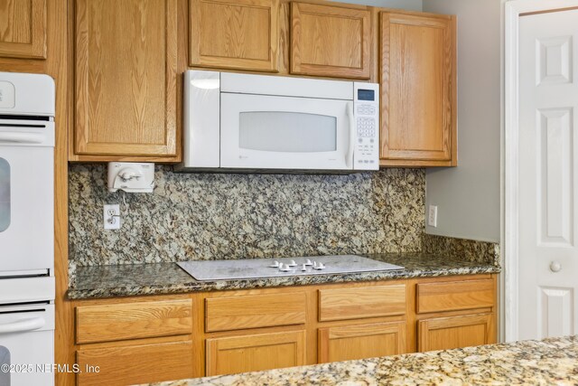 76466 Long Leaf Loop, Yulee, FL 32097 - kitchen with white appliances, decorative backsplash, and dark stone counters