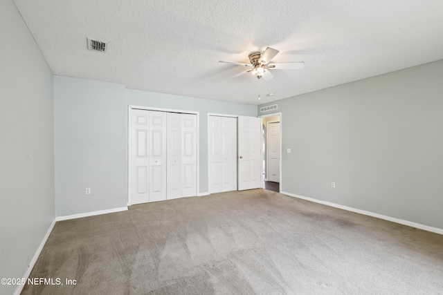 76466 Long Leaf Loop, Yulee, FL 32097 - unfurnished bedroom with multiple closets, carpet flooring, baseboards, and a textured ceiling