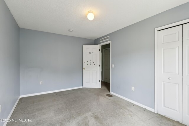 76466 Long Leaf Loop, Yulee, FL 32097 - unfurnished bedroom with carpet flooring, baseboards, a textured ceiling, and a closet