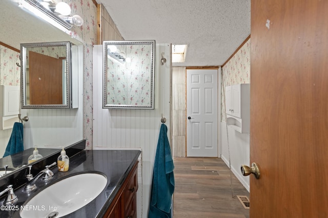 112 Sculpin Dr, Florahome, FL 32140 - bathroom with wallpapered walls, a textured ceiling, vanity, and wood finished floors