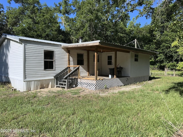 112 Sculpin Dr, Florahome, FL 32140 - back of property featuring a lawn, metal roof, and view of wooded area