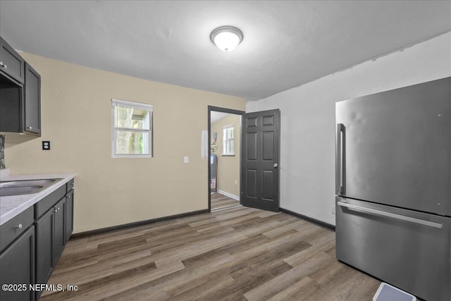 2058 W 40th St, Jacksonville, FL 32209 - kitchen with freestanding refrigerator, light countertops, wood finished floors, baseboards, and a sink