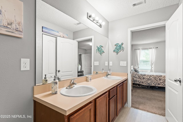 2840 Buck Creek Pl, Green Cove Springs, FL 32043 - ensuite bathroom featuring a textured ceiling, double vanity, and wood finished floors