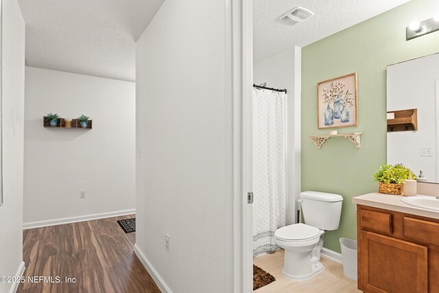 2840 Buck Creek Pl, Green Cove Springs, FL 32043 - full bathroom featuring toilet, wood finished floors, vanity, baseboards, and a textured ceiling