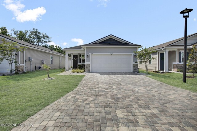 267 Honeycomb Trl, Saint Augustine, FL 32095 - view of front facade with decorative driveway, a front lawn, an attached garage, and stone siding