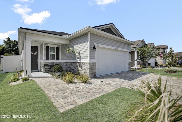 267 Honeycomb Trl, Saint Augustine, FL 32095 - view of front of property featuring an attached garage, stone siding, driveway, and a porch