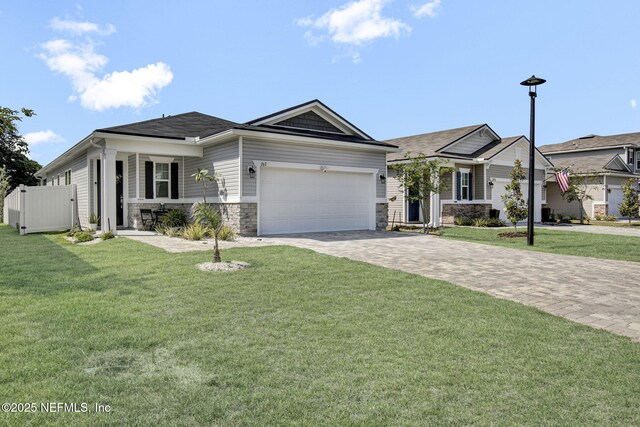 267 Honeycomb Trl, Saint Augustine, FL 32095 - view of front of property featuring an attached garage, decorative driveway, stone siding, and a shingled roof