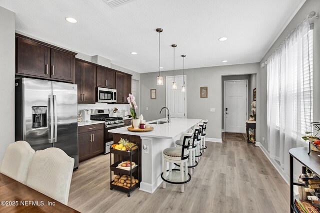 267 Honeycomb Trl, Saint Augustine, FL 32095 - kitchen featuring stainless steel appliances, light countertops, dark brown cabinetry, light wood-style flooring, and recessed lighting