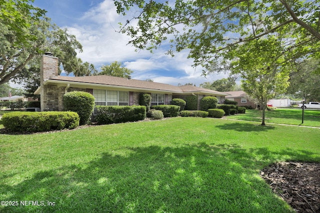 359 Carson Dr, Orange Park, FL 32073 - ranch-style house featuring a chimney, a front yard, and brick siding