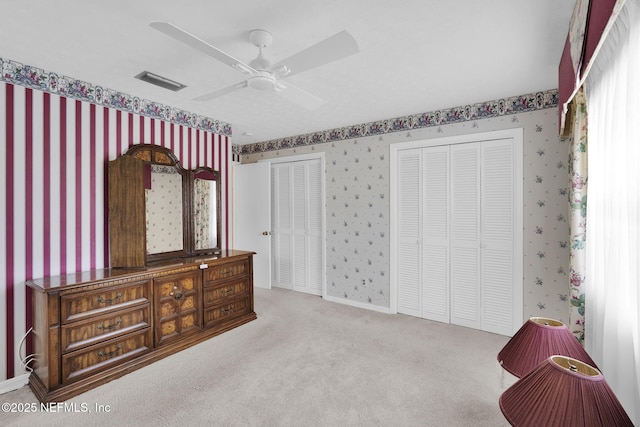 359 Carson Dr, Orange Park, FL 32073 - carpeted bedroom featuring wallpapered walls, two closets, and a ceiling fan
