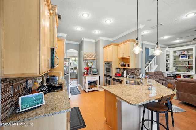 85053 Sagaponack Dr, Fernandina Beach, FL 32034 - kitchen with a sink, light brown cabinetry, open floor plan, a peninsula, and light wood-type flooring