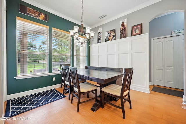 85053 Sagaponack Dr, Fernandina Beach, FL 32034 - dining area with a chandelier, ornamental molding, healthy amount of natural light, and light wood-style flooring