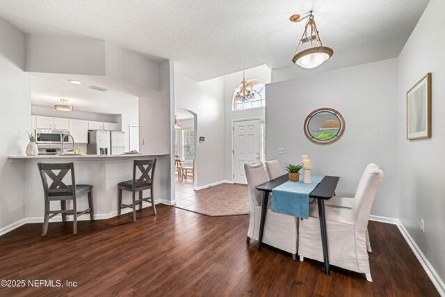 1491 Cedar Grove Ter, Fleming Island, FL 32003 - dining room featuring dark wood finished floors, a chandelier, baseboards, and a textured ceiling