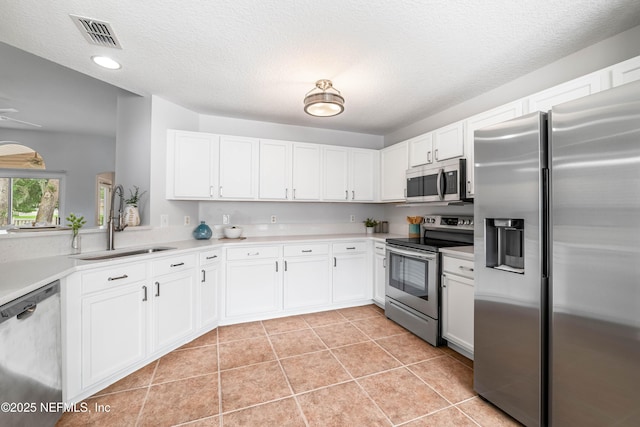 1491 Cedar Grove Ter, Fleming Island, FL 32003 - kitchen featuring stainless steel appliances, a sink, light countertops, white cabinets, and light tile patterned floors
