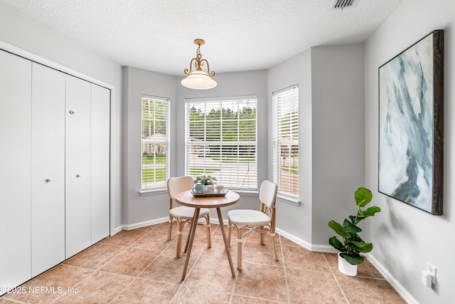 1491 Cedar Grove Ter, Fleming Island, FL 32003 - dining space with light tile patterned flooring, a textured ceiling, and baseboards