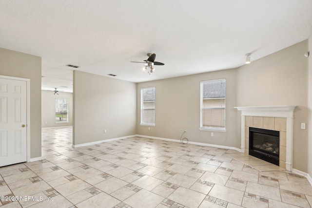 2454 Woodstork Ct, Saint Augustine, FL 32092 - unfurnished living room featuring a ceiling fan, a tiled fireplace, light tile patterned floors, and baseboards
