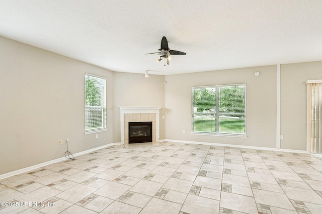 2454 Woodstork Ct, Saint Augustine, FL 32092 - unfurnished living room featuring ceiling fan, healthy amount of natural light, a tiled fireplace, baseboards, and a textured ceiling
