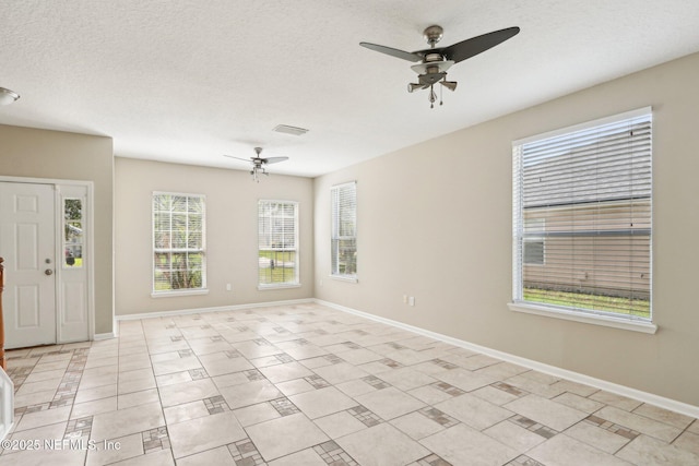 2454 Woodstork Ct, Saint Augustine, FL 32092 - empty room featuring a ceiling fan, baseboards, a textured ceiling, and light tile patterned floors