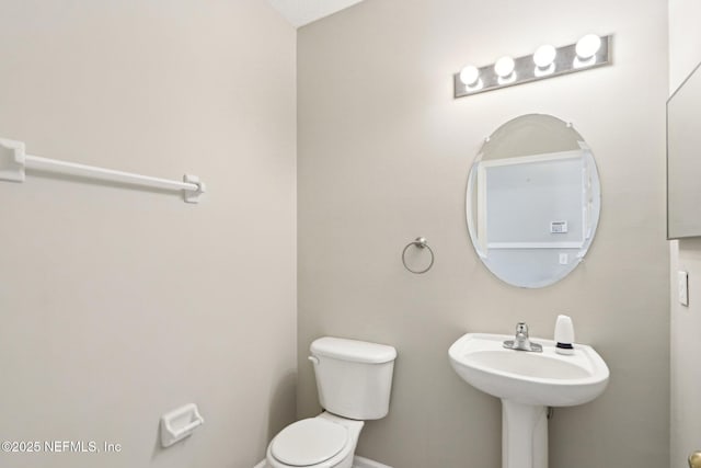 2454 Woodstork Ct, Saint Augustine, FL 32092 - half bathroom featuring toilet, baseboards, and a sink