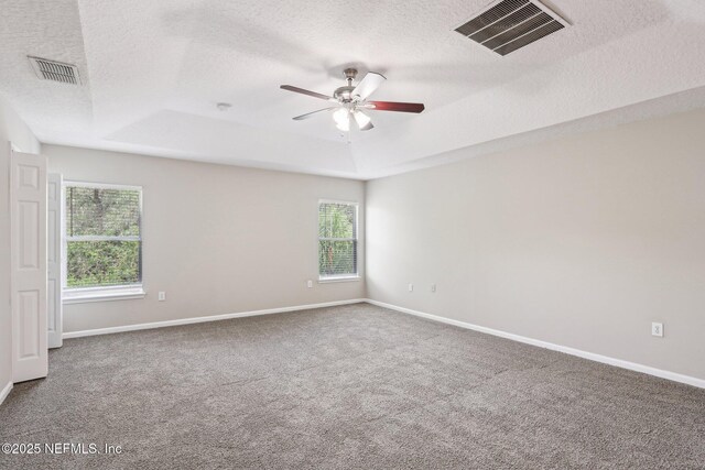2454 Woodstork Ct, Saint Augustine, FL 32092 - carpeted empty room with a tray ceiling, a textured ceiling, a ceiling fan, and baseboards