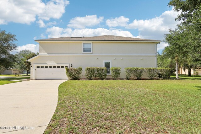 2454 Woodstork Ct, Saint Augustine, FL 32092 - view of side of home featuring concrete driveway, a garage, a lawn, and stucco siding