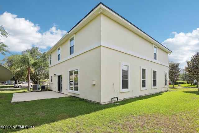 2454 Woodstork Ct, Saint Augustine, FL 32092 - back of property featuring a patio, a lawn, central AC, and stucco siding