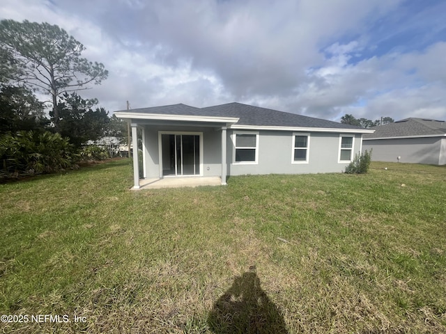 32 Pershing Ln, Palm Coast, FL 32164 - rear view of house featuring a lawn, stucco siding, and a patio