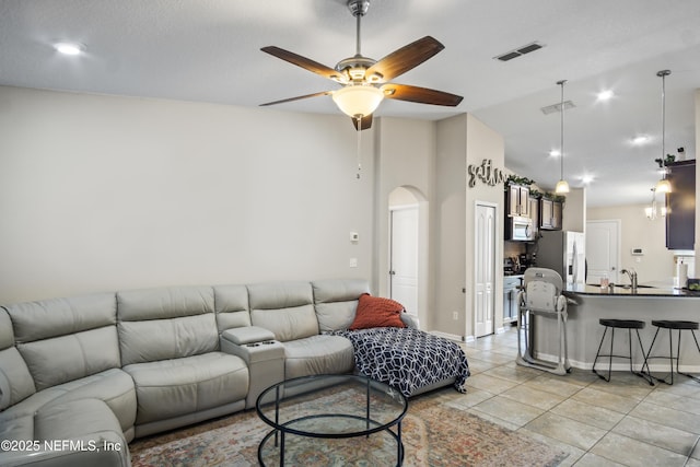 15831 Baxter Creek Dr, Jacksonville, FL 32218 - living room with arched walkways, a ceiling fan, light tile patterned floors, vaulted ceiling, and baseboards
