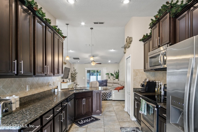 15831 Baxter Creek Dr, Jacksonville, FL 32218 - kitchen featuring stainless steel appliances, a sink, open floor plan, tasteful backsplash, and dark stone counters