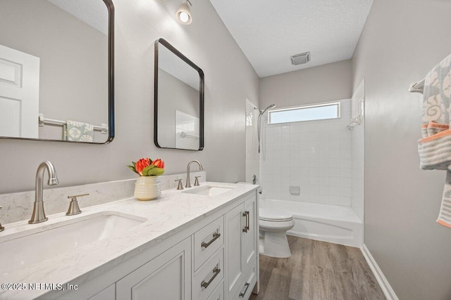 1211 Spring Branch Rd, Saint Johns, FL 32259 - bathroom with wood finished floors, toilet, shower / bathtub combination, double vanity, and a textured ceiling