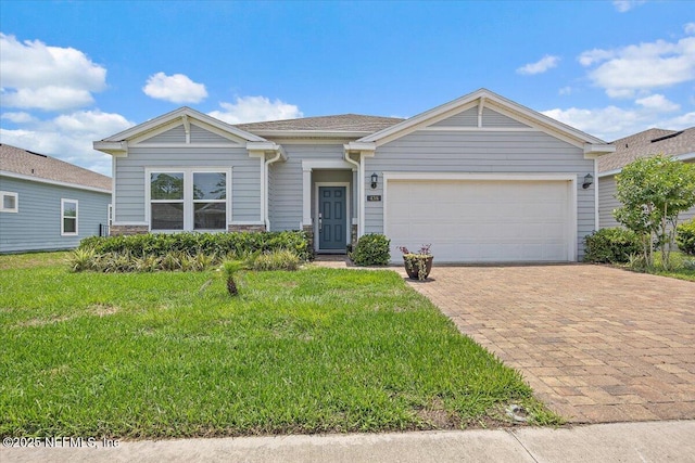 438 Stone Arbor Ln, Saint Augustine, FL 32086 - view of front of house featuring driveway, a front lawn, an attached garage, and stone siding