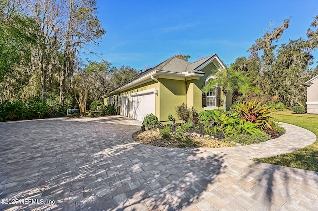 3461 Mainard Branch Ct, Fleming Island, FL 32003 - view of home's exterior featuring stucco siding, a garage, and decorative driveway