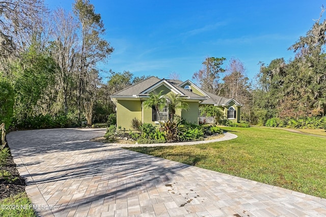 3461 Mainard Branch Ct, Fleming Island, FL 32003 - ranch-style home with stucco siding, a front yard, and decorative driveway