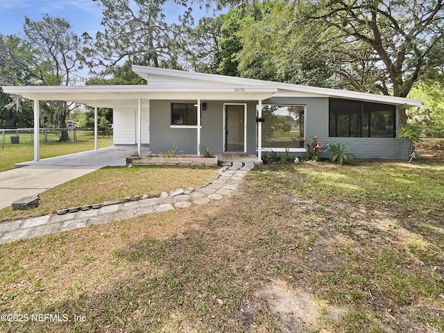 8636 Bermuda Rd, Jacksonville, FL 32208 - view of front of home featuring concrete driveway, an attached carport, a sunroom, covered porch, and stucco siding