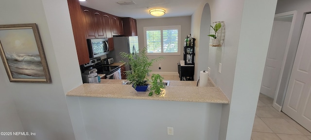 9745 Touchton Rd Unit 1521, Jacksonville, FL 32246 - kitchen featuring appliances with stainless steel finishes, light tile patterned floors, and a peninsula