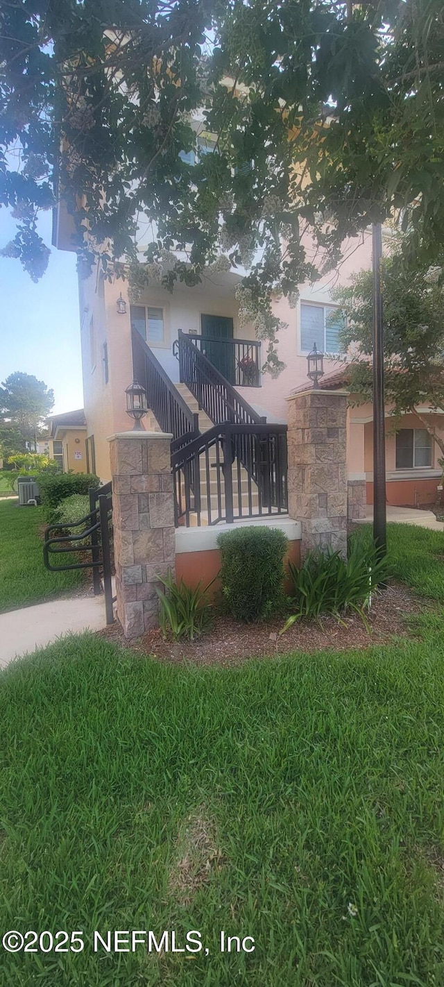 9745 Touchton Rd Unit 1521, Jacksonville, FL 32246 - exterior space with stucco siding, stone siding, a lawn, stairway, and central air condition unit