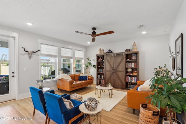 102 Blue Oak Ct, Ponte Vedra, FL 32081 - living area featuring light wood finished floors, ceiling fan, a textured ceiling, recessed lighting, and a barn door