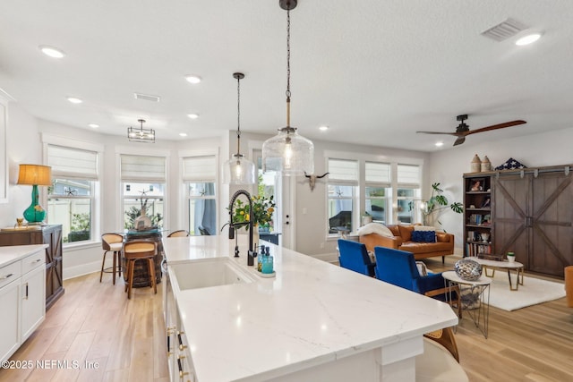 102 Blue Oak Ct, Ponte Vedra, FL 32081 - kitchen featuring a sink, light wood-type flooring, white cabinetry, recessed lighting, and hanging light fixtures