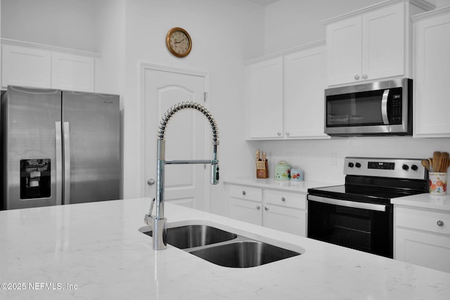 3075 Rustic Deer Way, Green Cove Springs, FL 32043 - kitchen with appliances with stainless steel finishes, white cabinetry, and light stone countertops